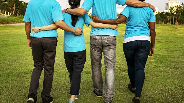 volunteers-in-blue-tshirtst-walking-in-a-field