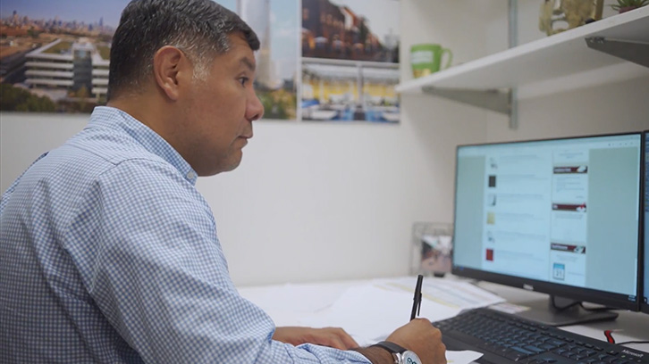 Man sitting at computer and writing