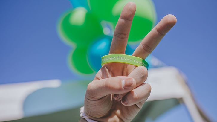 hand-with-a-peace-sign-in-front-of-balloons