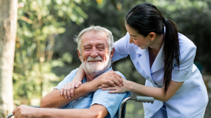 happy-man-in-wheelchair-and-with-a-nurse-smiling